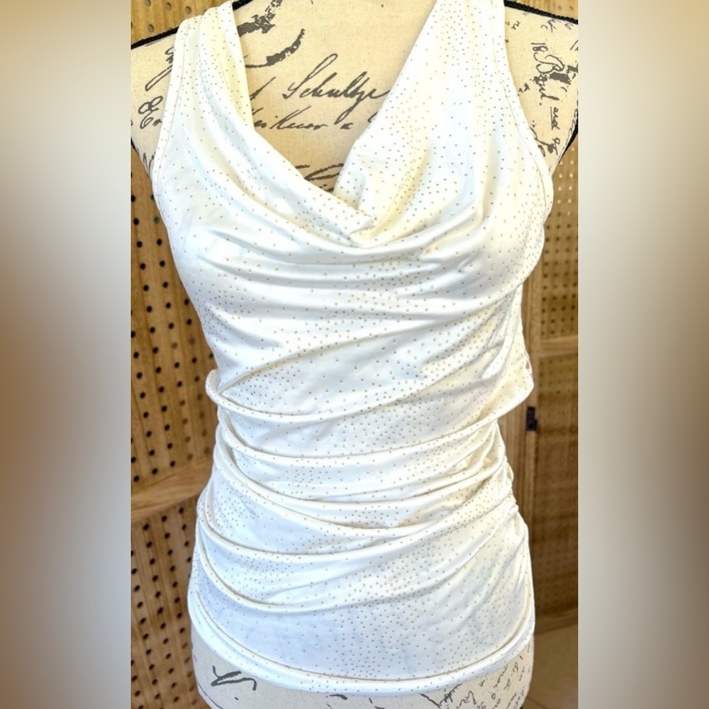 Cream color sleeveless top.Has Gold color Dots and a lace see through back.